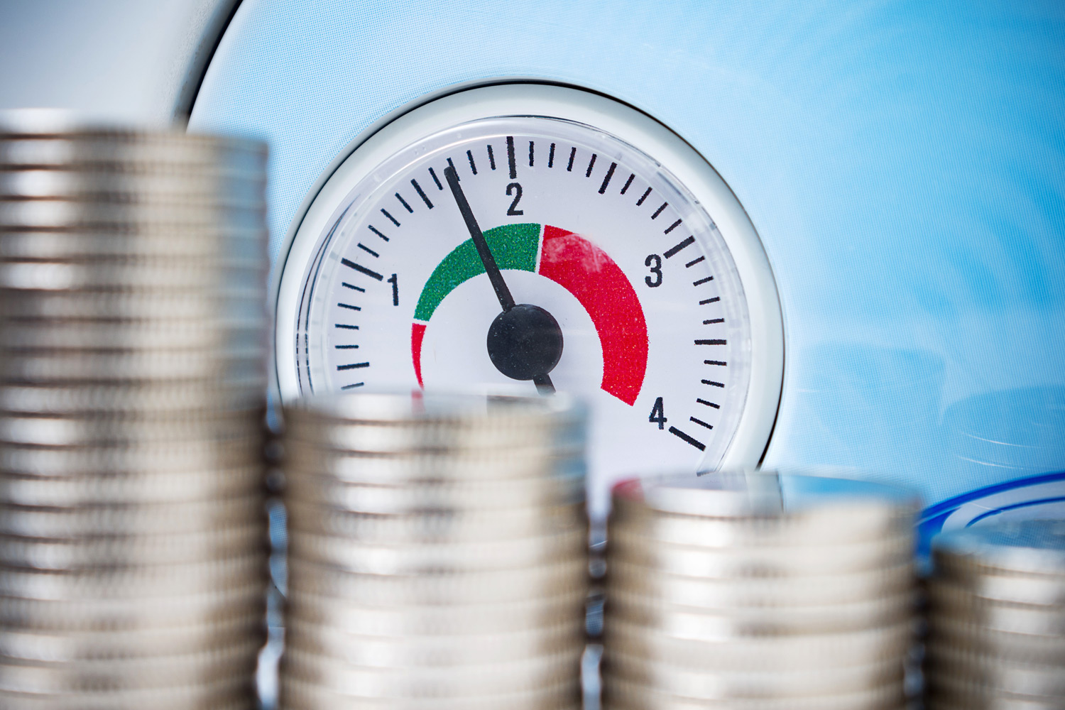Boiler pressure gauge beside stacks of coins
